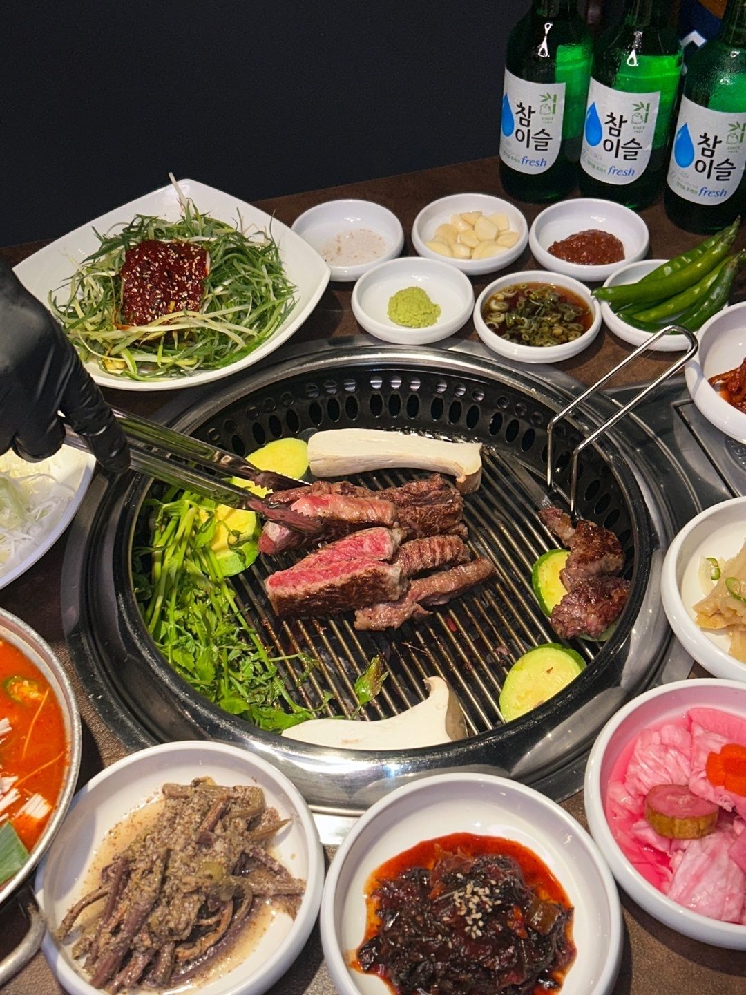 육끝 영통구청점의 숯불 화로에 올린 소고기와 한 상 차림